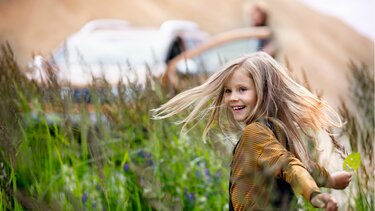 Glückliches Mädchen am Familienausflug mit dem Dacia Duster