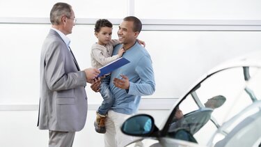 Vater mit Sohn bei der Anfrage für eine Finanzierung des neues Dacia Familienauto 