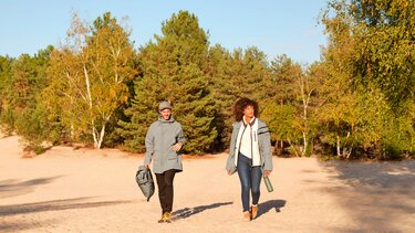 Frau und Mann wandern mit Dacia Rucksack und Dacia Trinkflasche