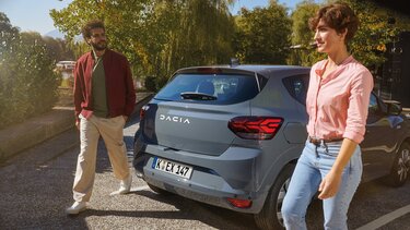 Frau und Mann laden ihre Einkäufe in den Dacia Sandero