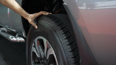 Person greift mit der Hand prüfend auf einen Reifen