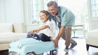 Vater und Sohn spielen mit einem Renault Spielzeugauto 