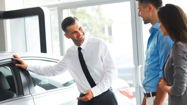 Verkäufer präsentiert den neune RENAULT einem Pärchen  