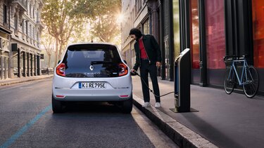 Der Renault Twingo E-Tech 100% elektrisch in der Stadt vor moderner Architektur