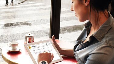 Frau liest den Renault Newsletter Electric auf einem iPad
