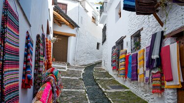 calle blanca con telares coloridos