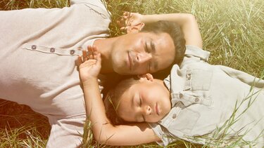 Vater und Tochter liegen in der Sonne
