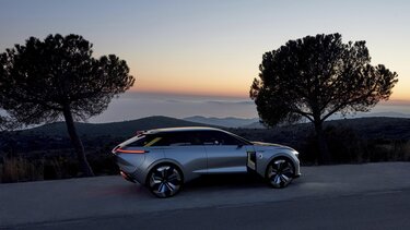 Renault Morphoz Concept car fährt bei Sonnenuntergang auf einer Landstraße
