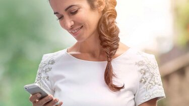 uśmiechnięta kobieta korzysta ze smartfona